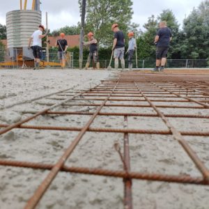 Mitarbeiter auf dem Bau verteilen Beton